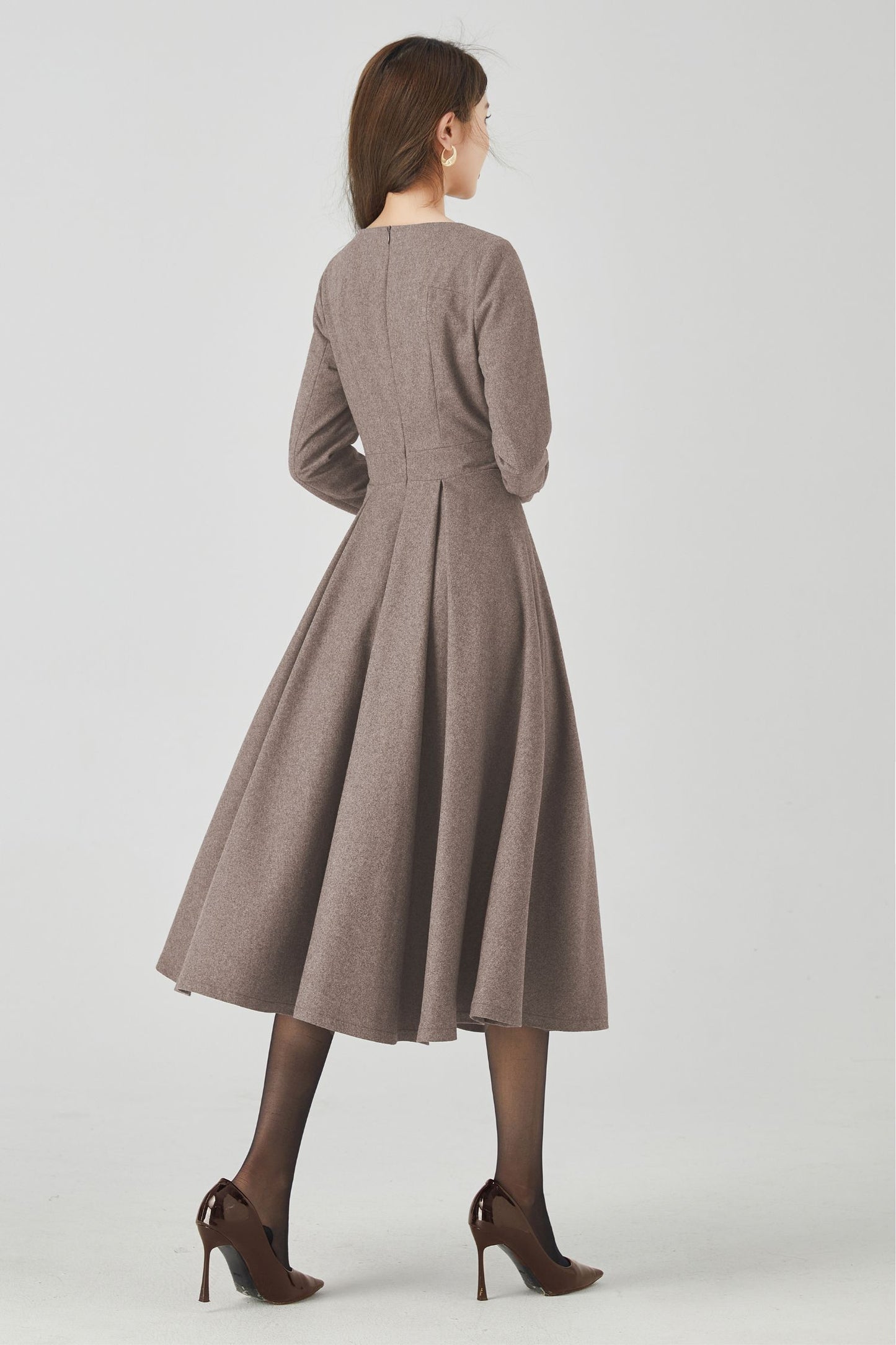 Woman wearing a brown dress on a white background