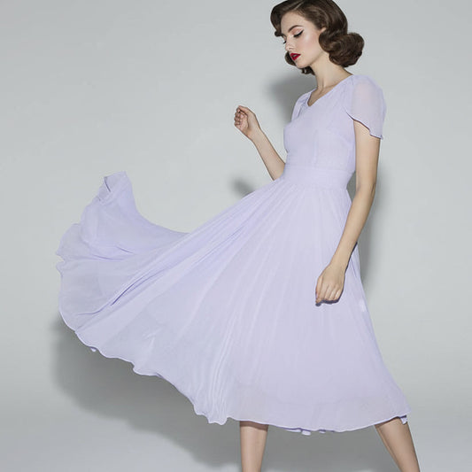 Woman wearing a light purple dress against a plain background