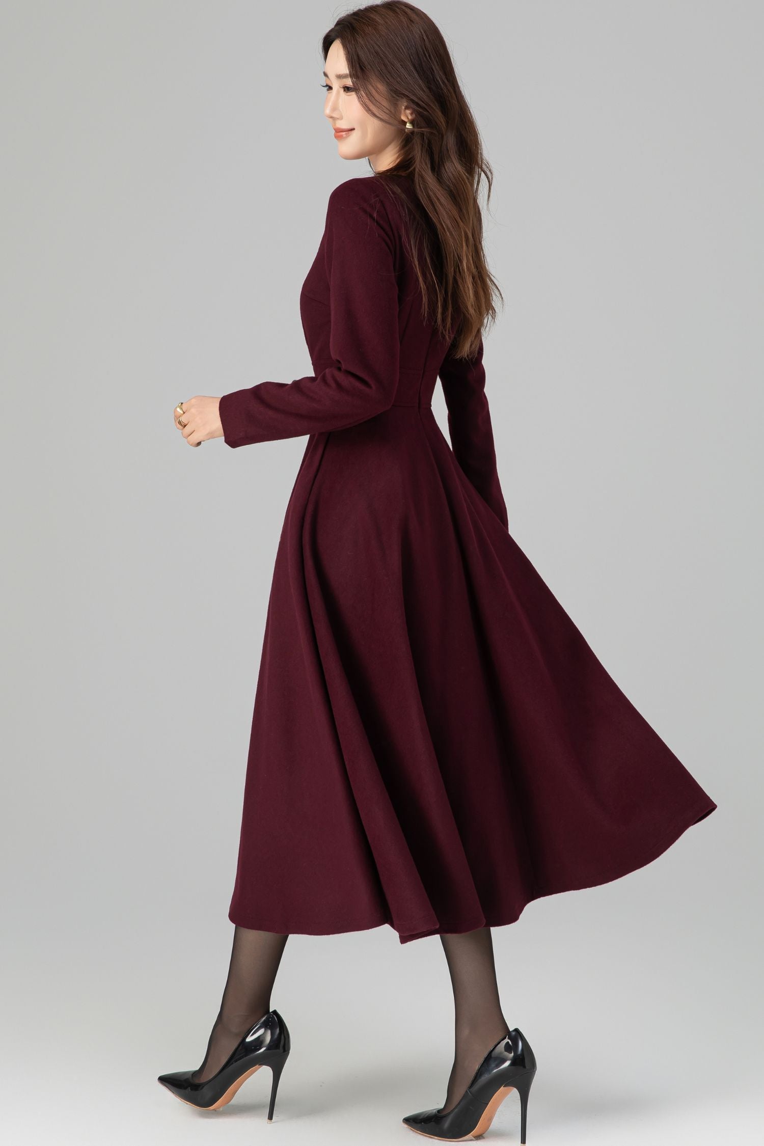 Woman wearing a burgundy dress on a gray background