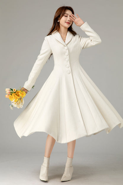 A woman in a white prom dress with a lace collar and long sleeves, holding a bouquet of flowers, standing in a twist pose.