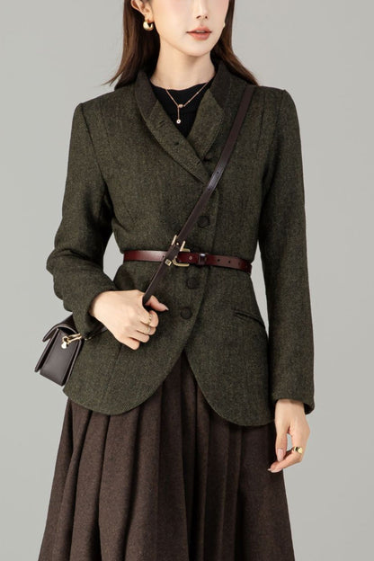 Woman wearing a dark green blazer and brown skirt with a plain background