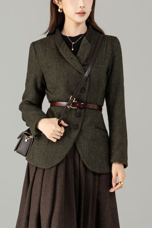 Woman wearing a dark green blazer and brown skirt with a plain background