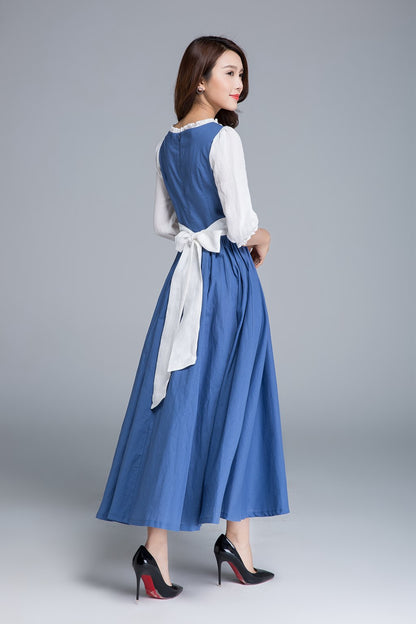 Woman wearing a blue dress with a white blouse on a gray background