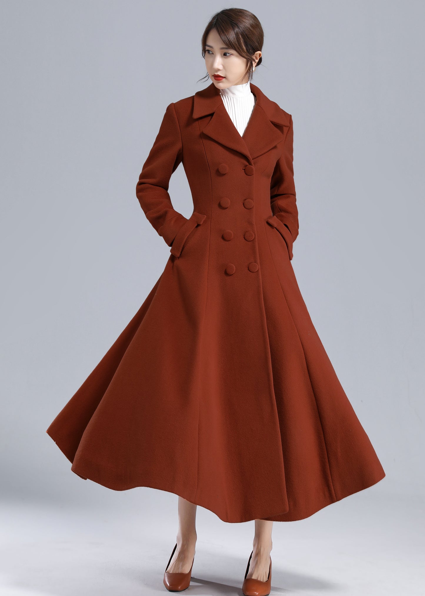 Woman wearing a brown coat on a gray background