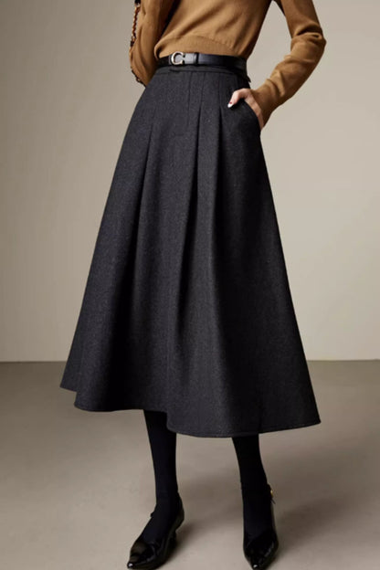 Woman wearing gray wool pleated midi skirt with lining and tailored silhouette