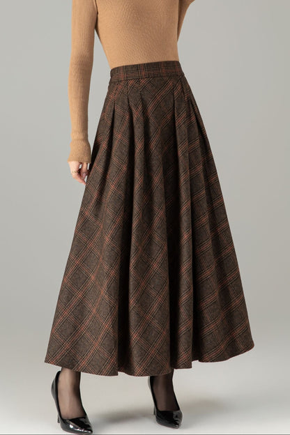Woman wearing a brown top and plaid skirt on a gray background