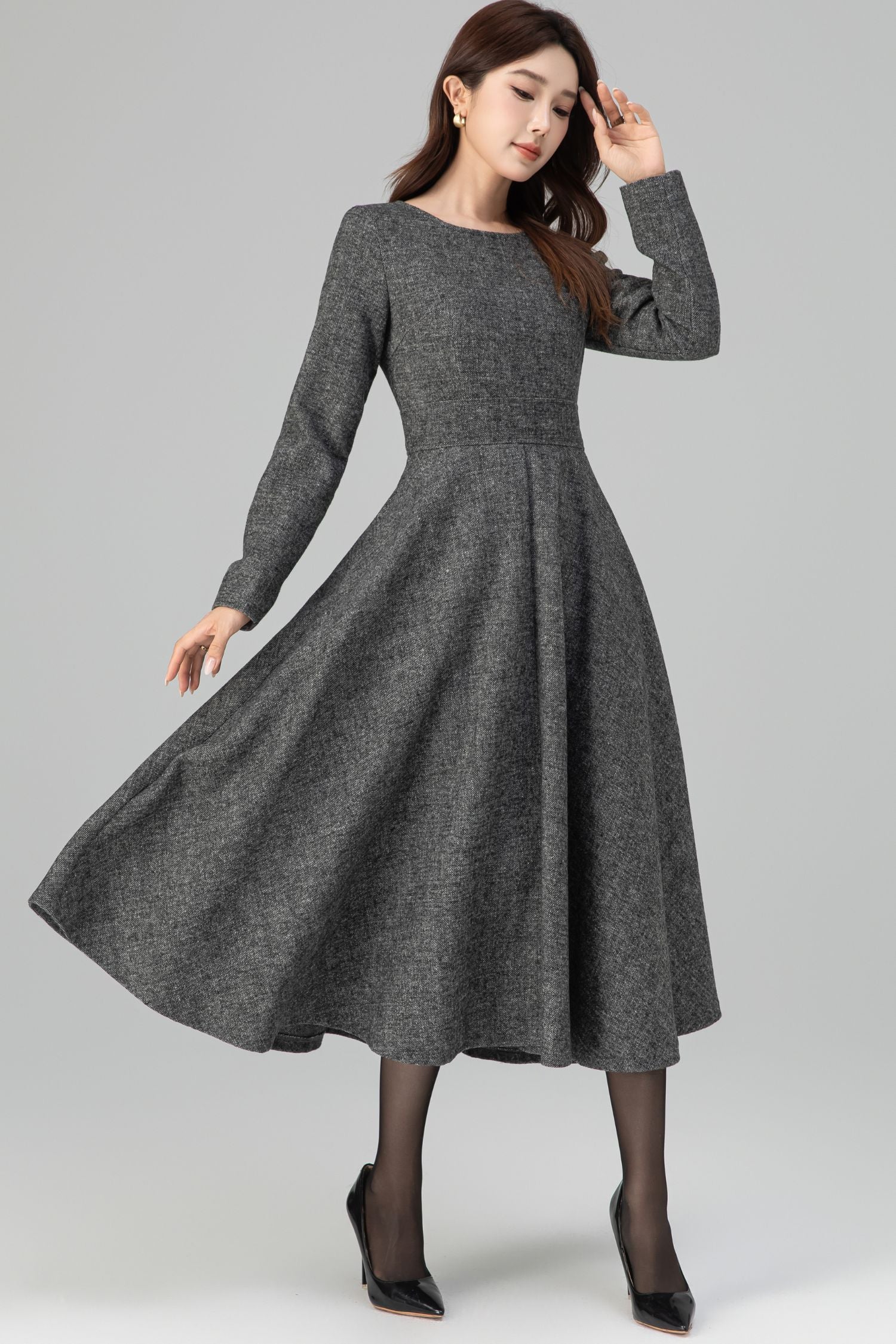 Woman wearing a gray dress on a plain background