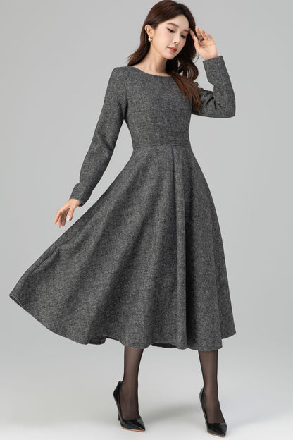 Woman wearing a gray dress on a plain background