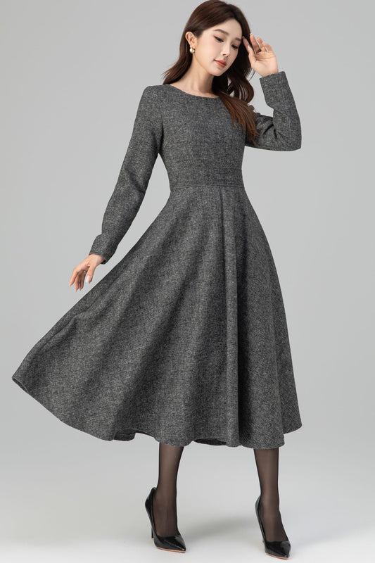 Woman wearing a gray dress on a plain background