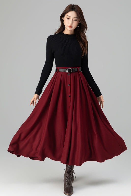 Woman wearing a black top and red skirt on a gray background