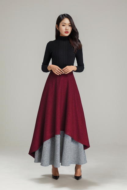 A woman wearing a red and gray layered wool skirt with a side zip closure, hip pockets, and an ankle-length cut.