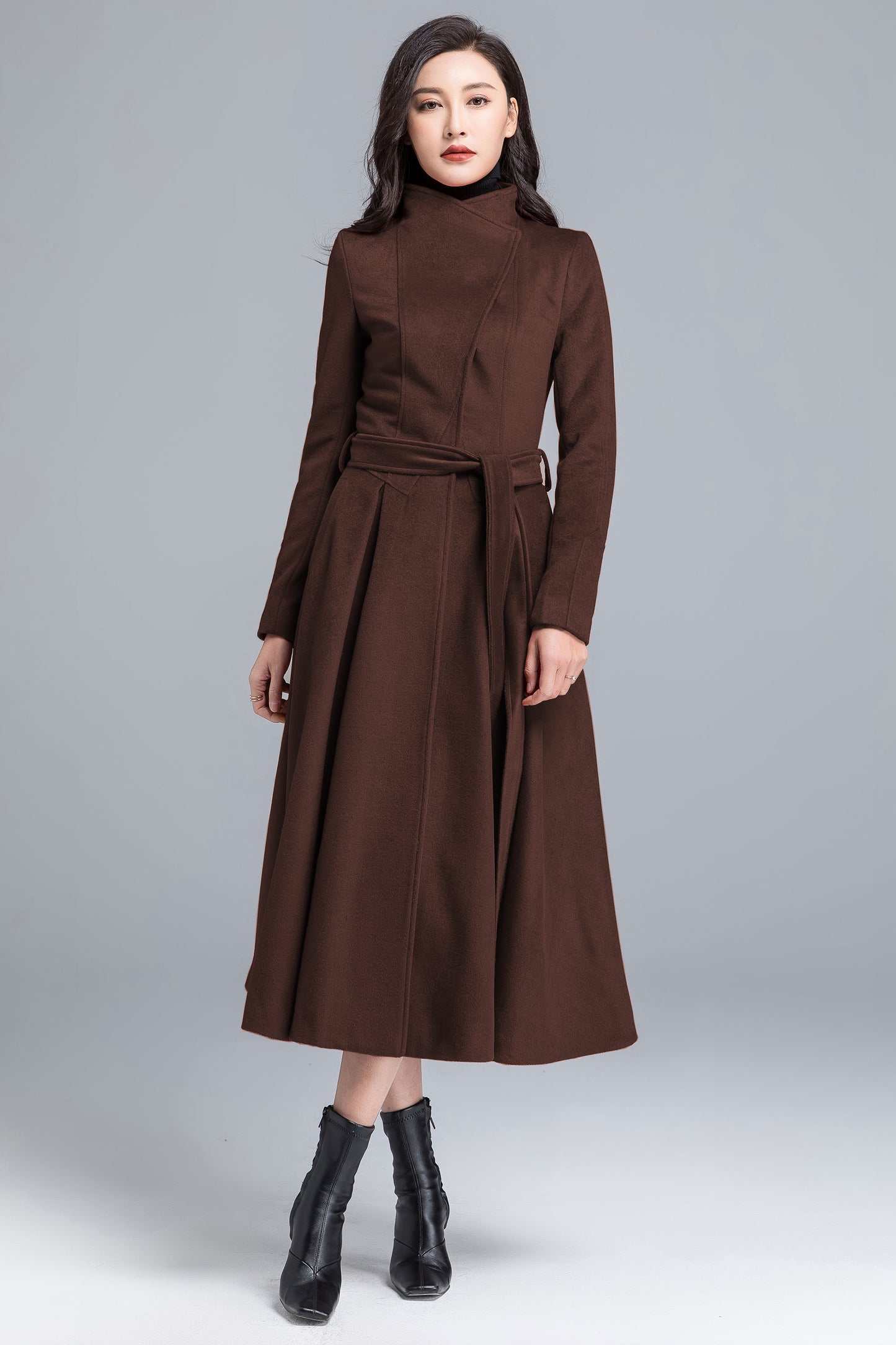 Woman wearing a brown coat on a gray background