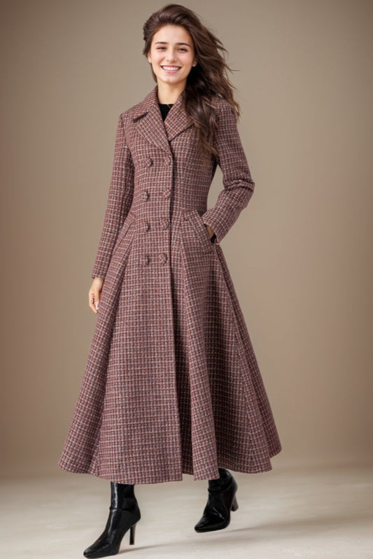 Woman wearing a long plaid coat against a neutral background
