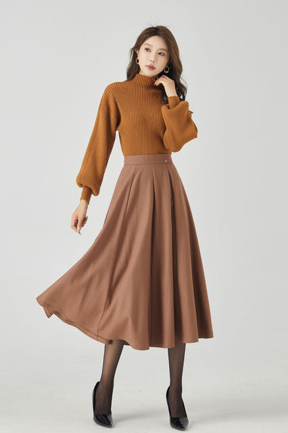 A woman modeling a brown swing high waisted circle skirt that reaches midi length. The skirt features a high waist and a round neckline.