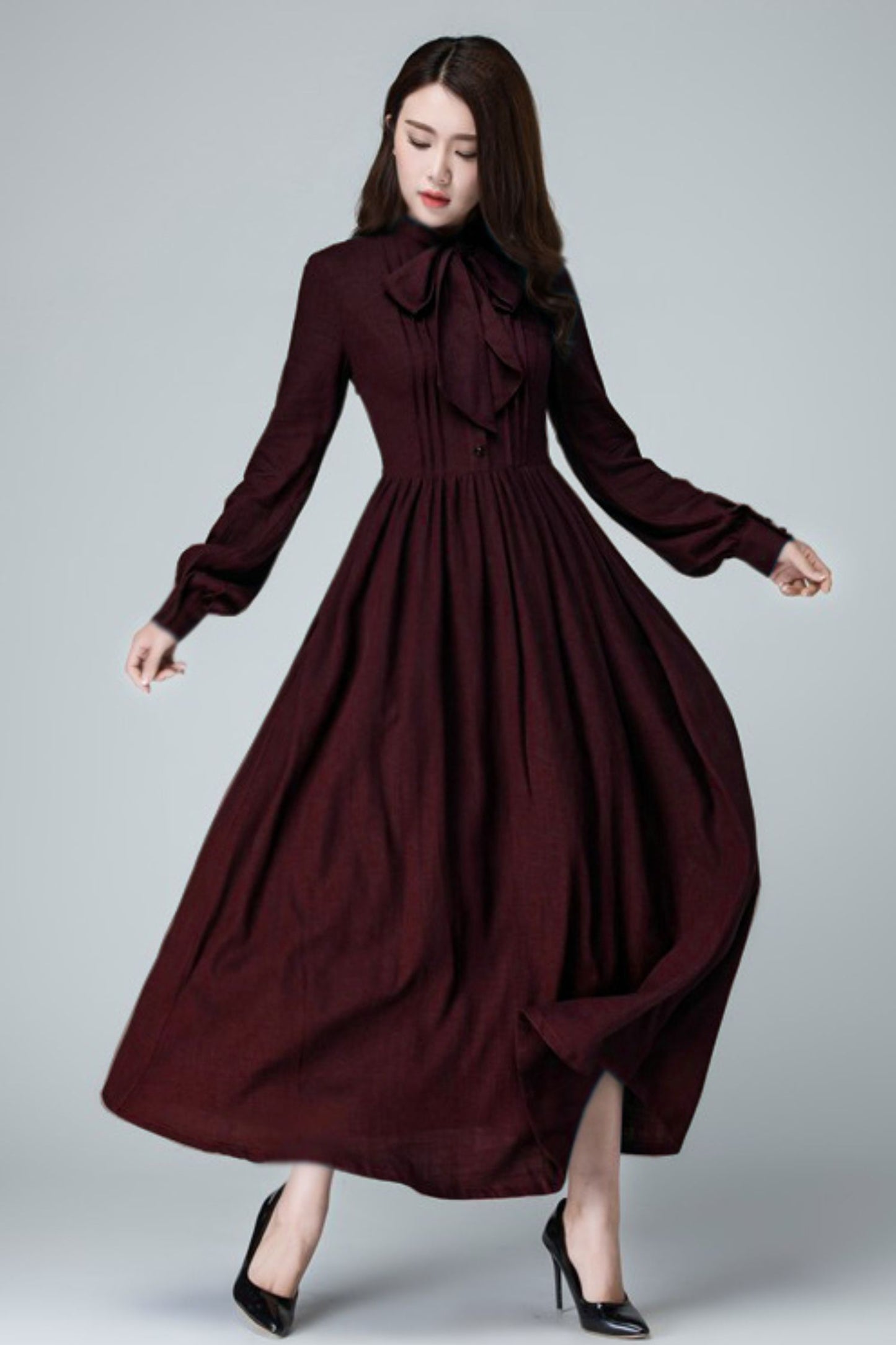 Woman wearing a burgundy dress on a gray background