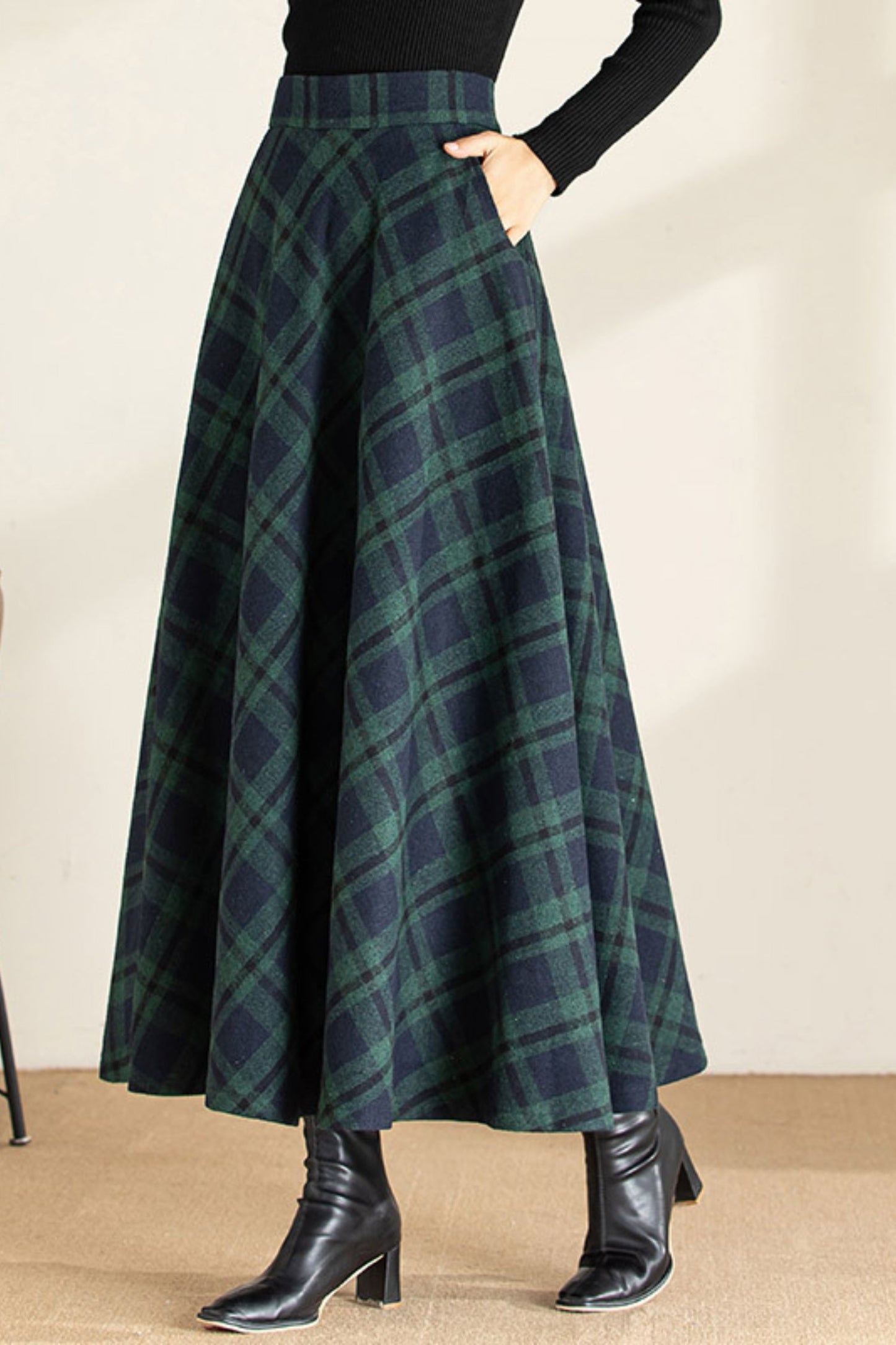 Green plaid skirt worn by a person on a beige background