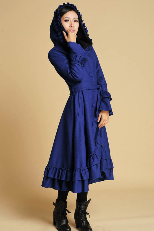 Woman wearing royal blue hooded wool maxi coat with ruffle hem and tie belt