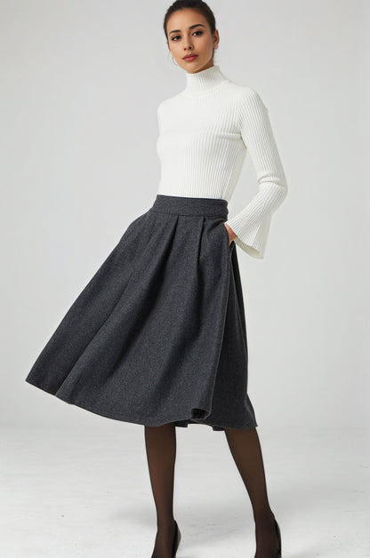 Woman wearing a white turtleneck and gray skirt on a white background