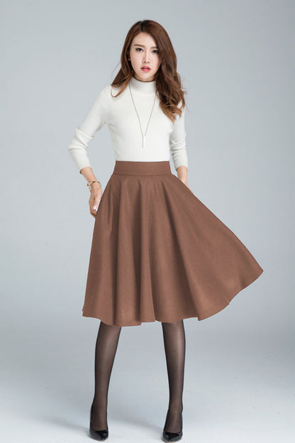 Woman wearing a white turtleneck and brown skirt on a gray background