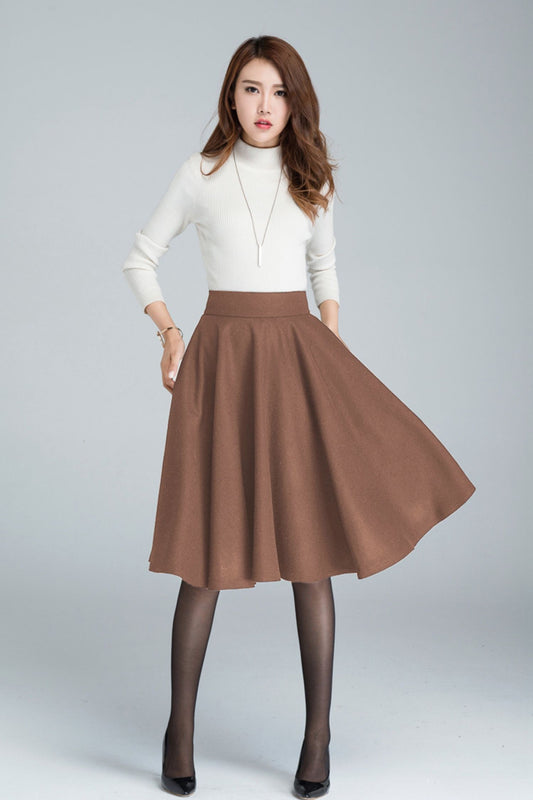 Woman wearing a white turtleneck and brown skirt on a gray background