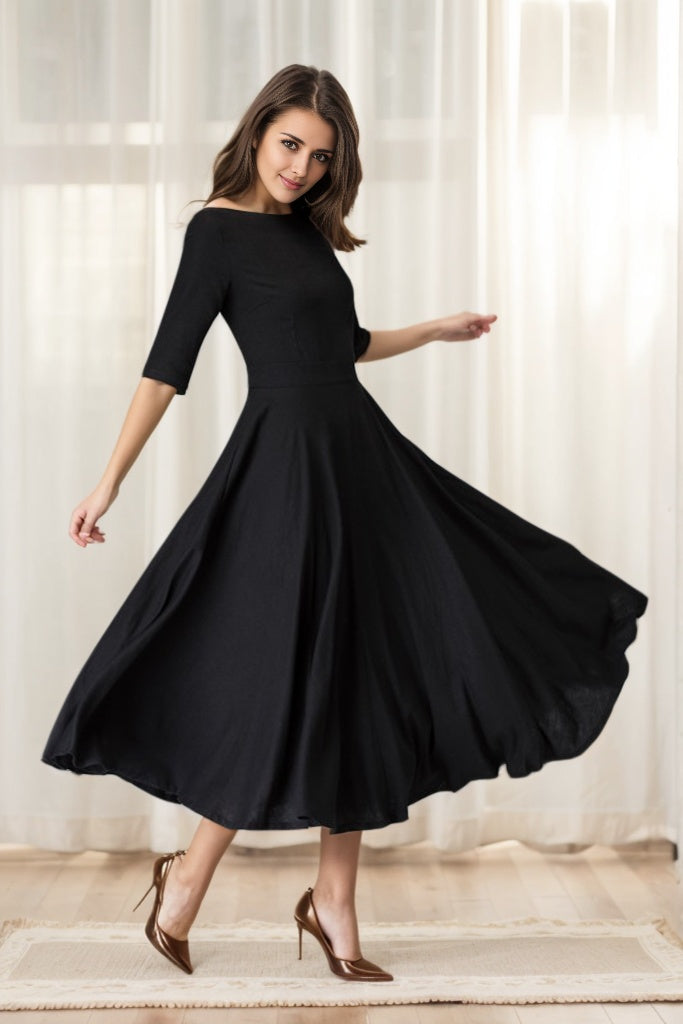 Woman wearing a black dress with a flowing skirt against a light curtain background