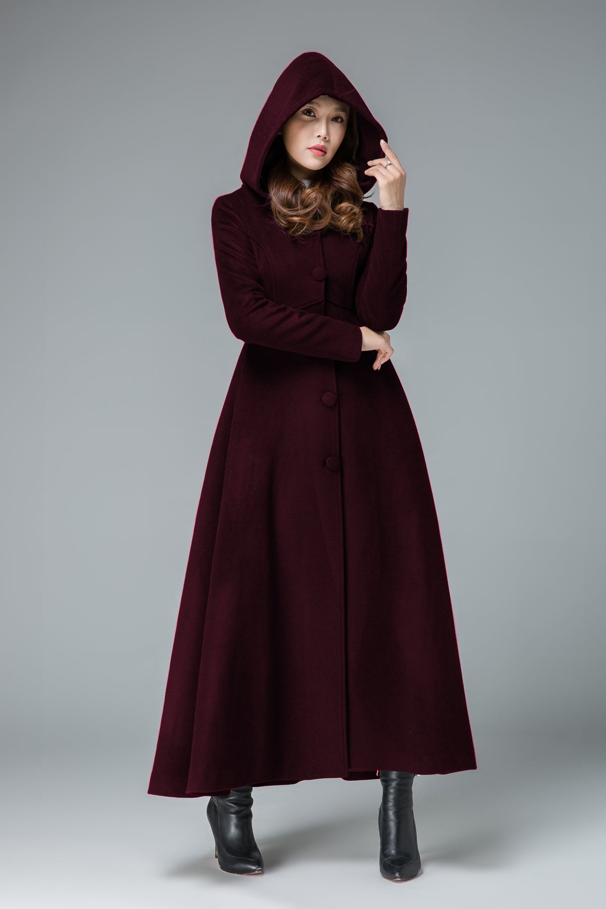 Woman wearing a vintage handmade hooded wool maxi coat in burgundy