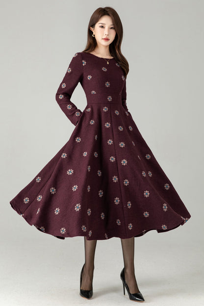 Woman wearing a burgundy dress with floral pattern on a gray background