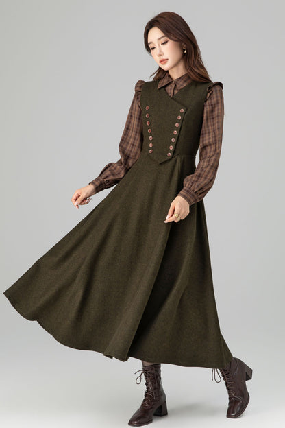 Woman wearing a long green dress with a plaid shirt underneath on a gray background