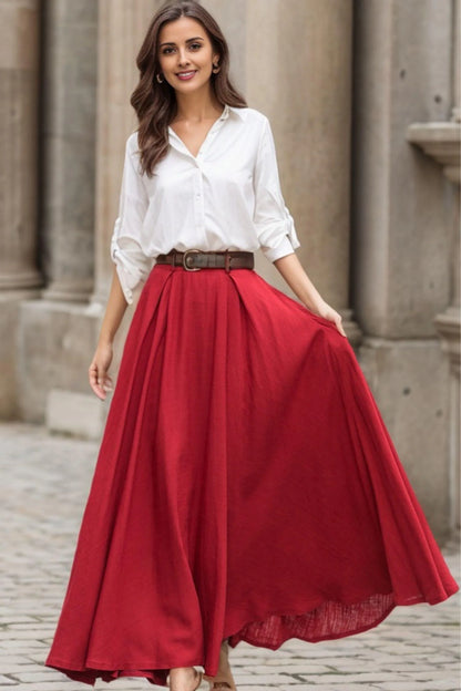 May include: A red maxi skirt with a brown belt. The skirt is pleated and has a flowy silhouette.