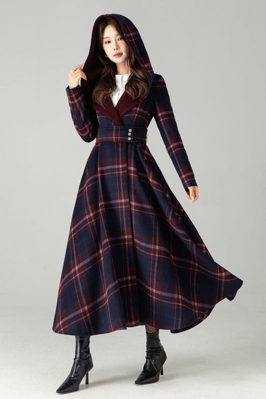 Woman wearing a long plaid coat on a gray background