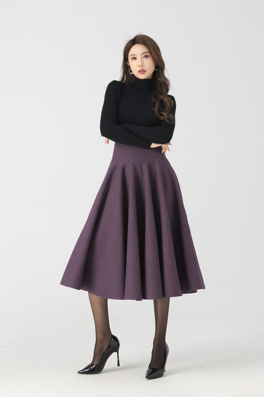 Woman wearing a black top and purple skirt on a white background