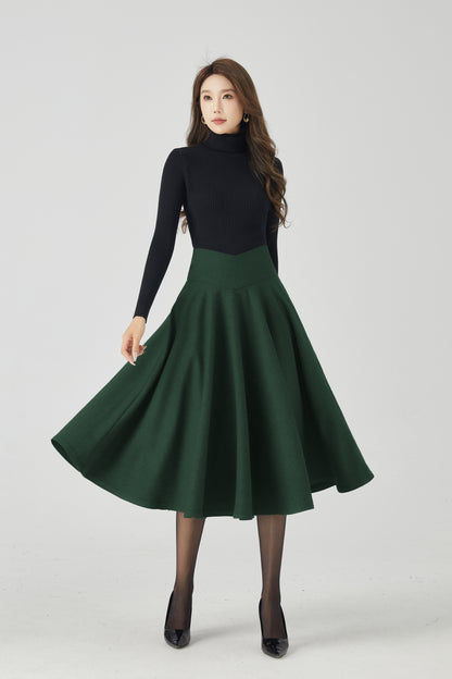 Woman wearing a black turtleneck and green skirt on a white background