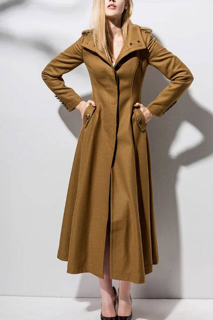 A woman modeling a brown maxi fit and flare winter warm wool coat with button closure, two side pockets, and long sleeves.