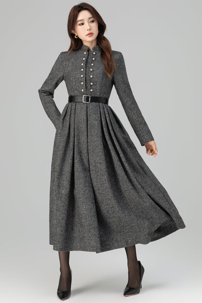 Woman wearing a gray long-sleeve dress with a belt on a white background