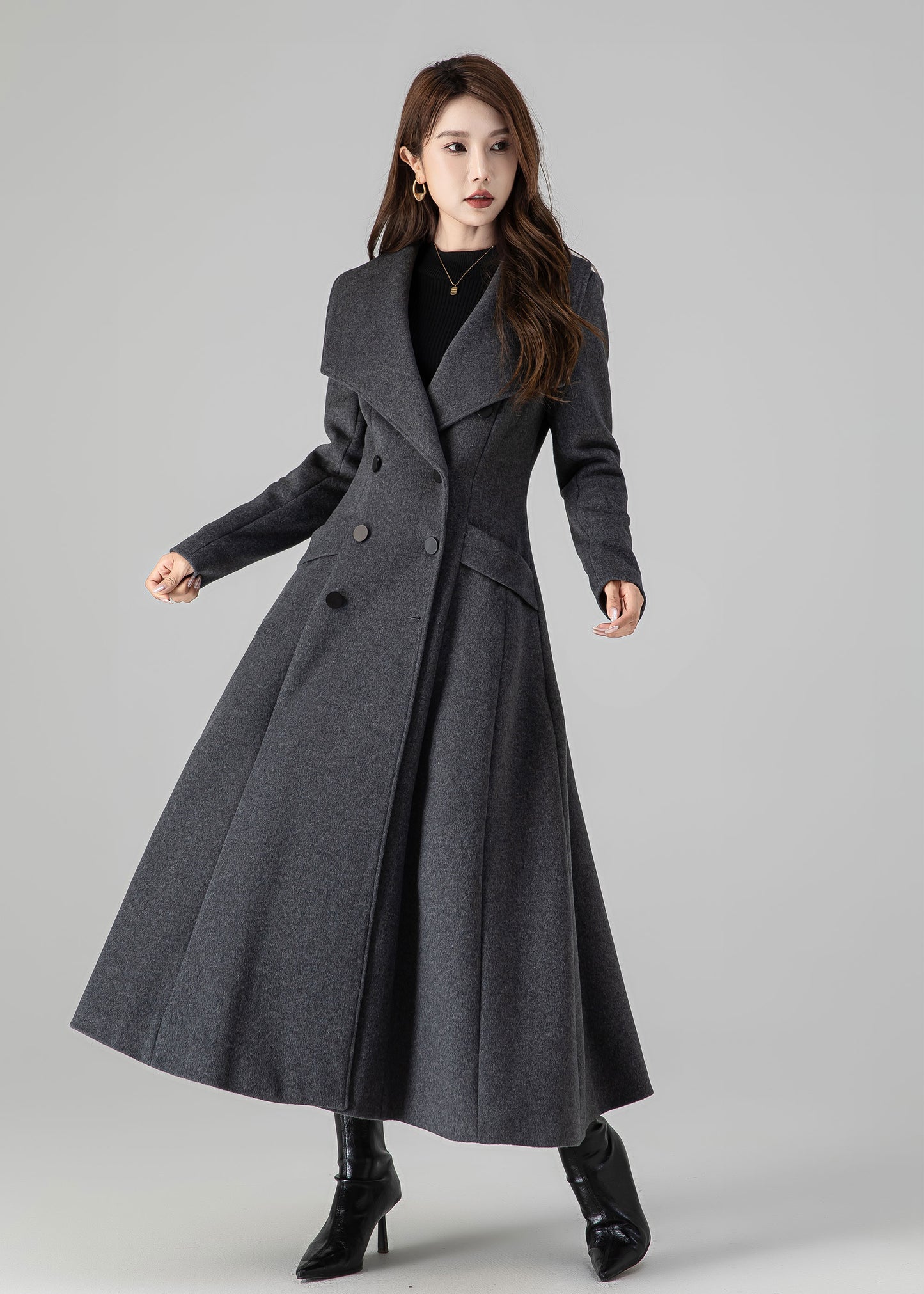 Woman wearing a long gray coat on a gray background