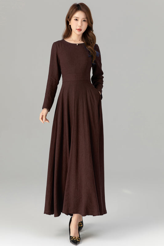 Woman wearing a brown long-sleeve dress on a gray background