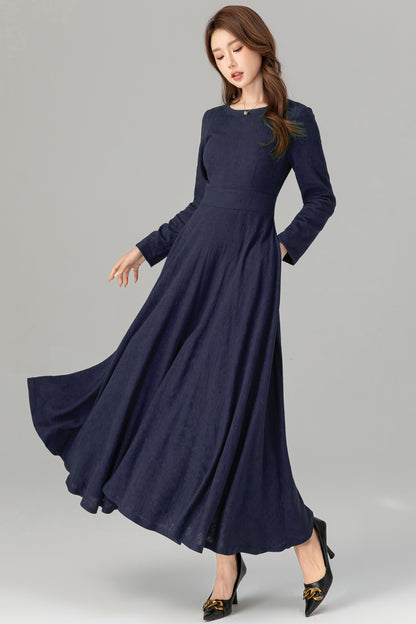 Woman wearing a long navy blue dress on a gray background