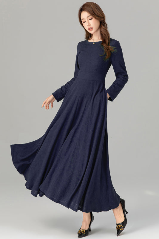 Woman wearing a long navy blue dress on a gray background