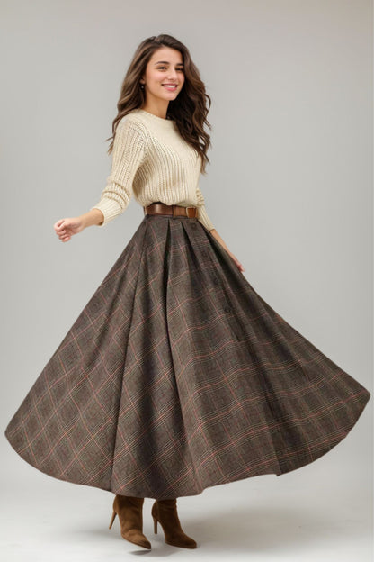 A woman modeling a long wool plaid winter skirt in a brown color with a beige belt loops.