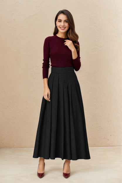 Woman wearing a burgundy sweater and black skirt against a beige background