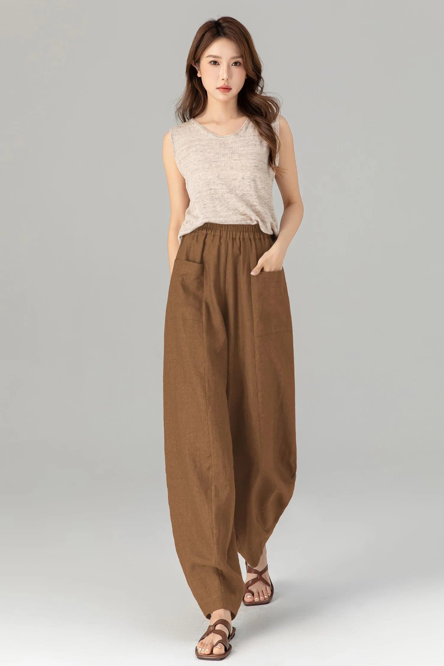 May include: Brown linen pants with a wide leg and elastic waistband. The pants have two large pockets on the front.
