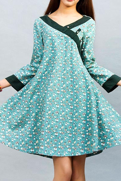Teal floral dress with green accents on a gray background