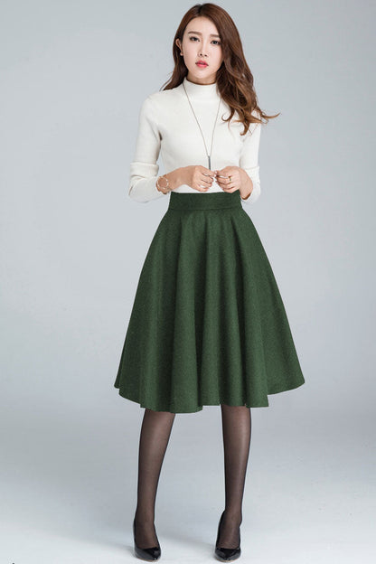 Woman wearing a white blouse and green skirt on a gray background