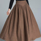 A woman wearing a brown high-waisted wool maxi skirt with a vintage-inspired A-line silhouette.