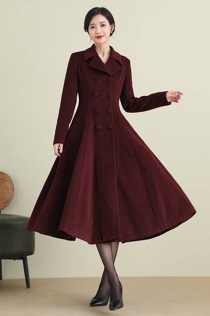 A woman modeling a wine red double-breasted wool coat with long sleeves and a button closure. The coat is presented against a plain background.