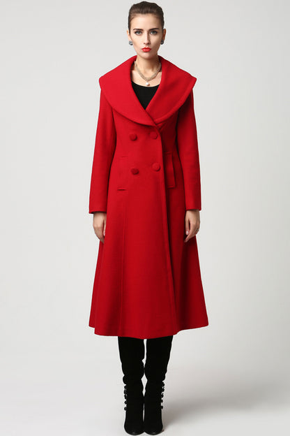 A woman standing and modeling a red wool double-breasted coat with long sleeves and a round neckline. The coat has a regular fit and features side pockets and a stitched panel detail at the waist.