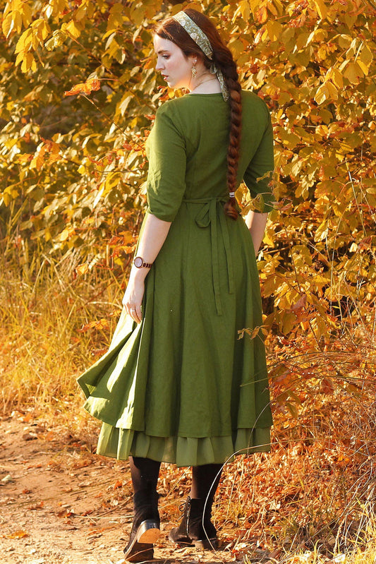 Woman in a green dress standing in an autumn forest