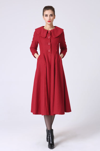 A woman wearing a red cashmere coat with long sleeves, a single-breasted front, and side pockets. The coat has a princess style epaulette and is adorned with red lace.
