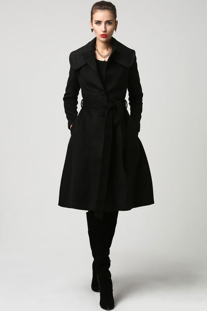 Model wearing a black wool belted coat with double folded collar