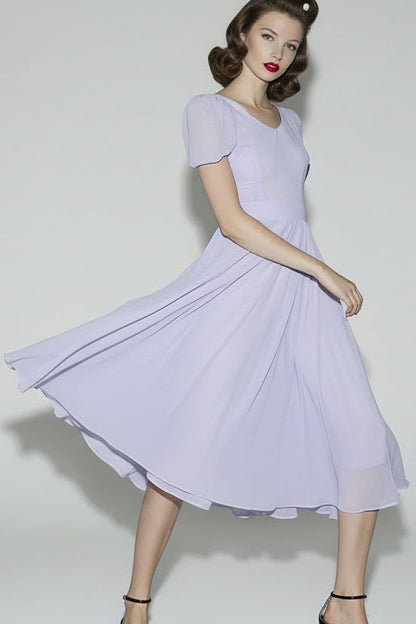 Woman wearing a light purple dress against a white background